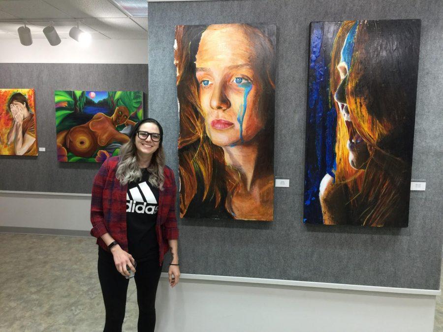 Art student, Rachel Hendrix stands by her painting at the opening of the Art Faculty/Art Student Exhibition.