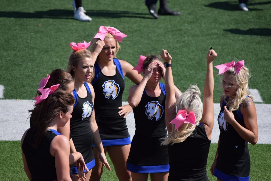 A few of the Southeastern cheerleaders focus in on their captain, Jamie Jackman, and her advice on how to improve a stunt meant for the game.