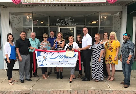 Bella Ragazza Boutique owner, Melissa Burrage, and Chamber of Commerce members meet in front of new location for ribbon cutting on September 12. 