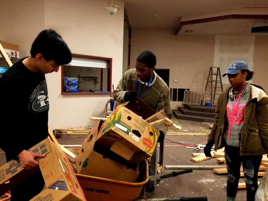 Dylan Candelora, Tay Pruitt and Jay Carr help remove trash from the J127 building on Jan. 21, 2019. Though volunteer activities may be different this year, their impact is not lessened.