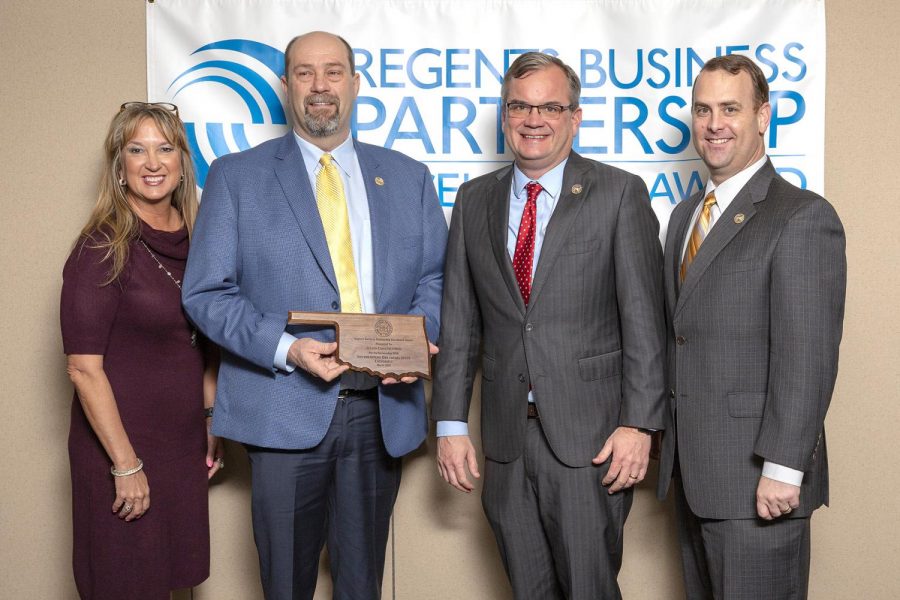 Tommy Julian accepts the Regents Business Partnership Award on March 12. Also shown are Oklahoma Small Business Development state director Michele Campbell, Southeastern president Sean Burrage, and Southeastern vice president for university advancement Dr. Kyle Stafford.