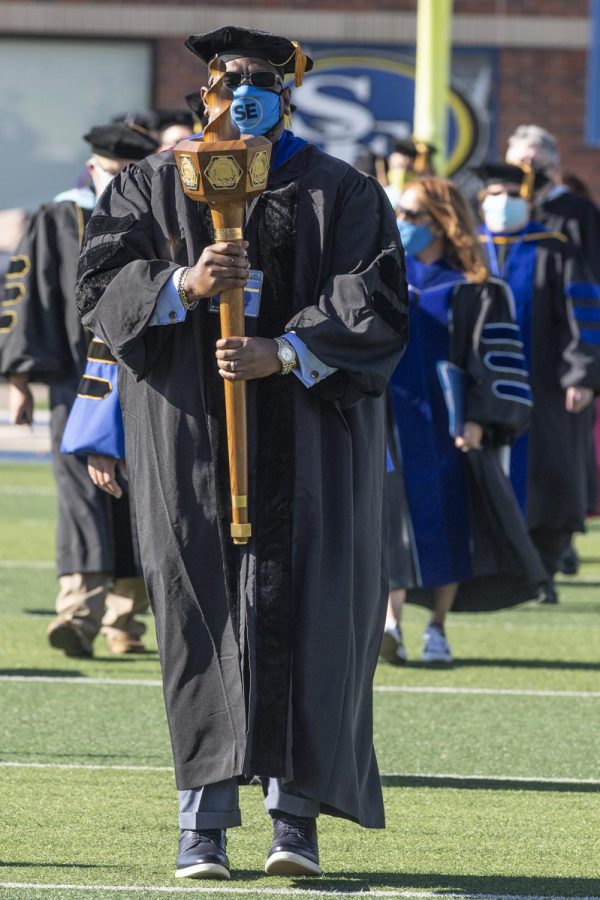 Dr. Randy Clark, communication professor and chair of the Faculty Senate,  bears the symbolic mace  at Friday’s commencement.